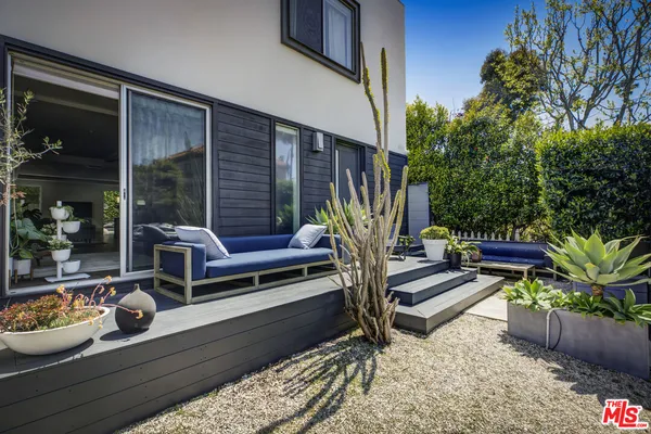 a view of a balcony with chairs and a potted plant