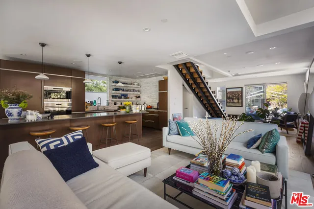 a living room with furniture kitchen view and a table