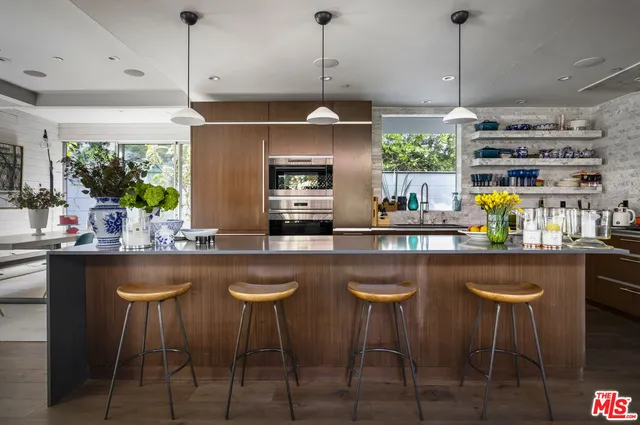 a kitchen with stainless steel appliances granite countertop a sink a window and chairs