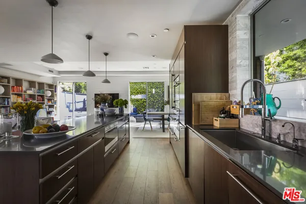 a kitchen with stainless steel appliances a counter space a sink and a large window