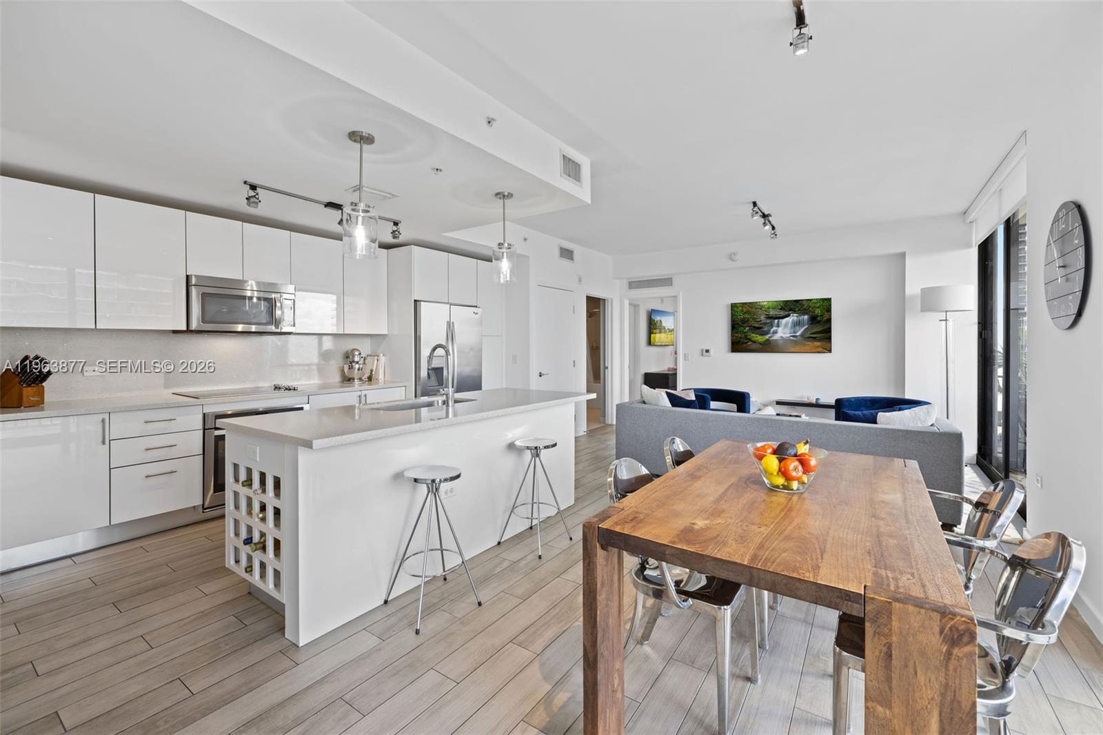 999 Southwest 1st Avenue, Unit 2303 Miami, FL 33130 - Photo 3 of 44 a kitchen with a sink a counter top space stainless steel appliances and cabinets