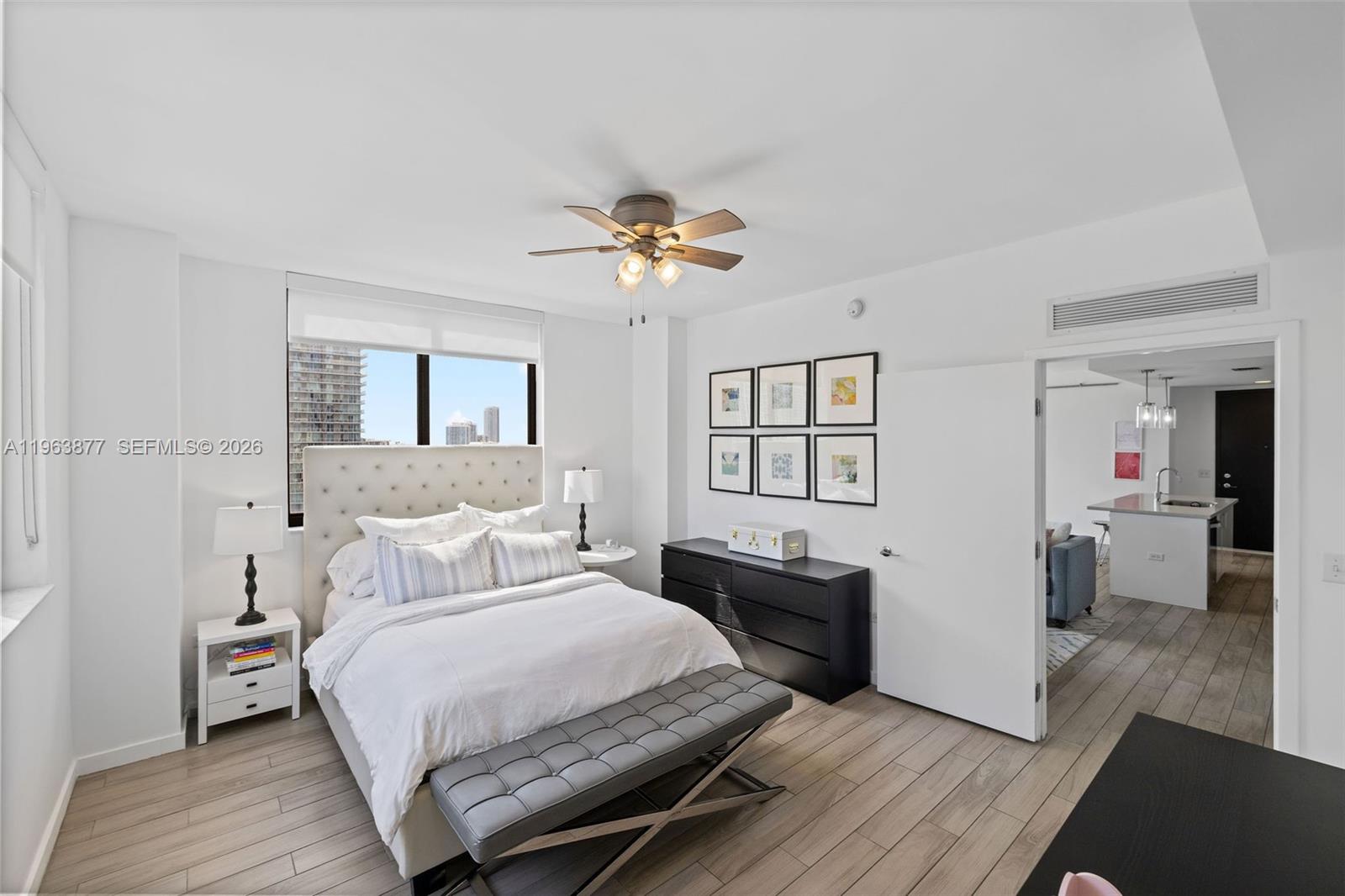 999 Southwest 1st Avenue, Unit 2303 Miami, FL 33130 - Photo 4 of 44 a bedroom with a bed and wooden floor