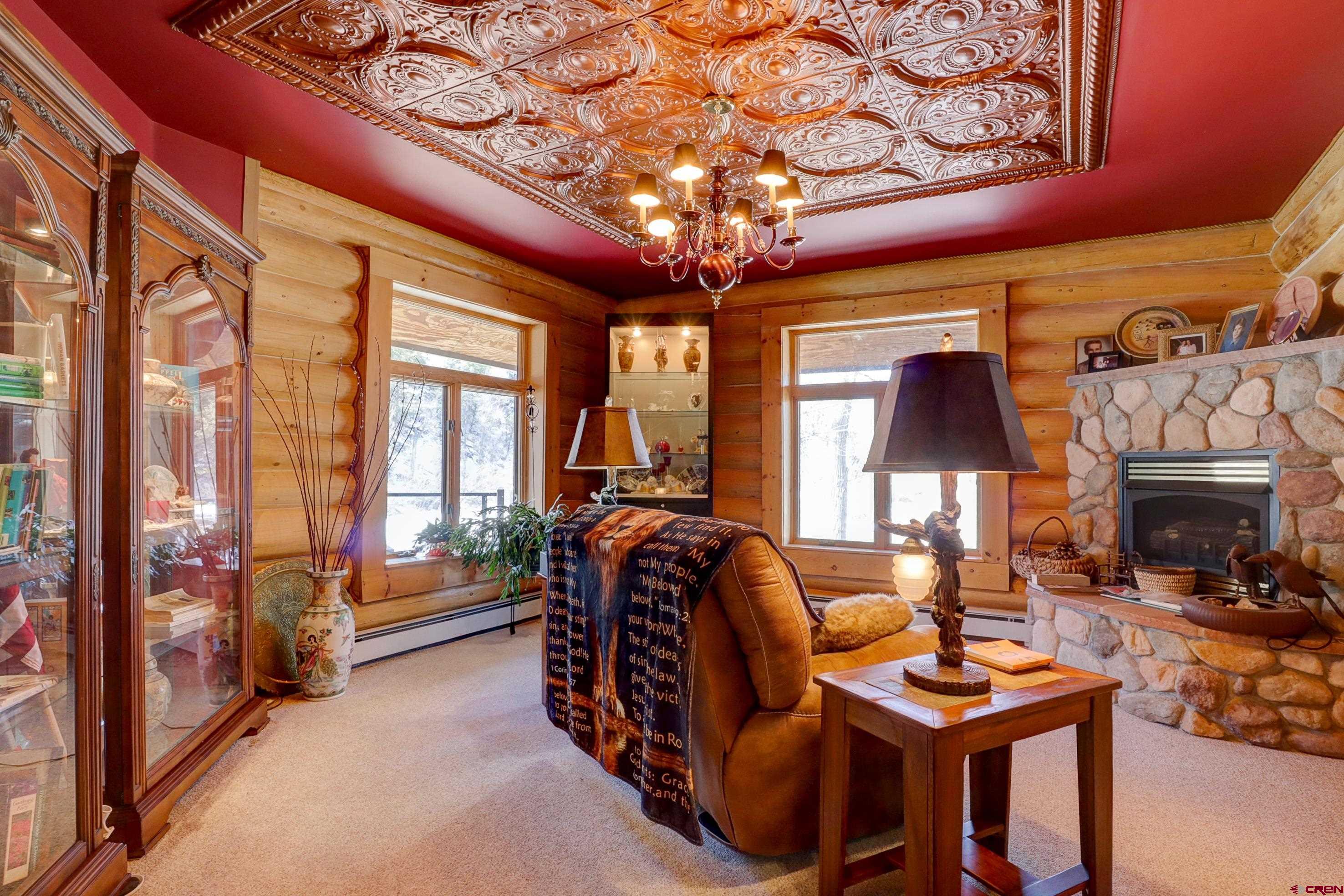 18656 Highway 145 Dolores, CO 81323 - Photo 12 of 45 Living room with a baseboard heating unit, plenty of natural light, light colored carpet, and a notable chandelier