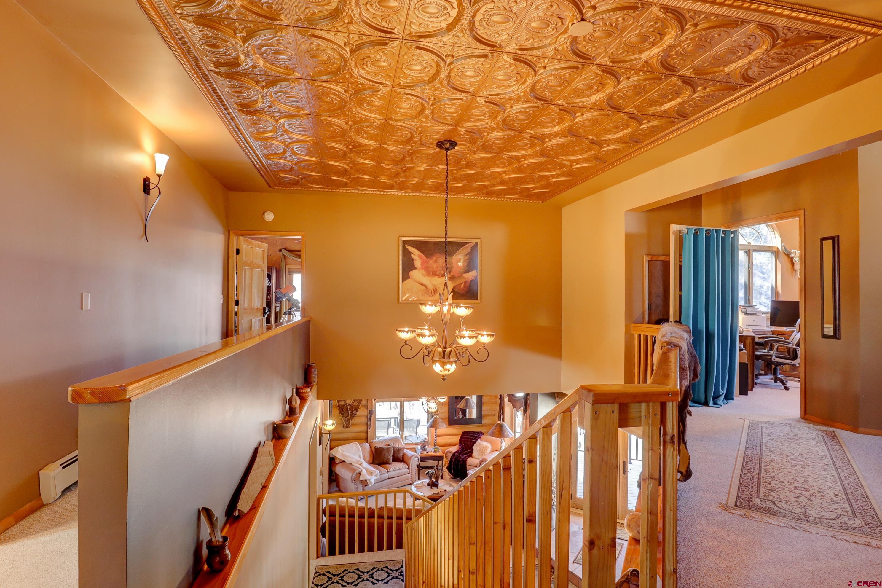 18656 Highway 145 Dolores, CO 81323 - Photo 20 of 45 Staircase with a notable chandelier, carpet flooring, an ornate ceiling, and a baseboard heating unit