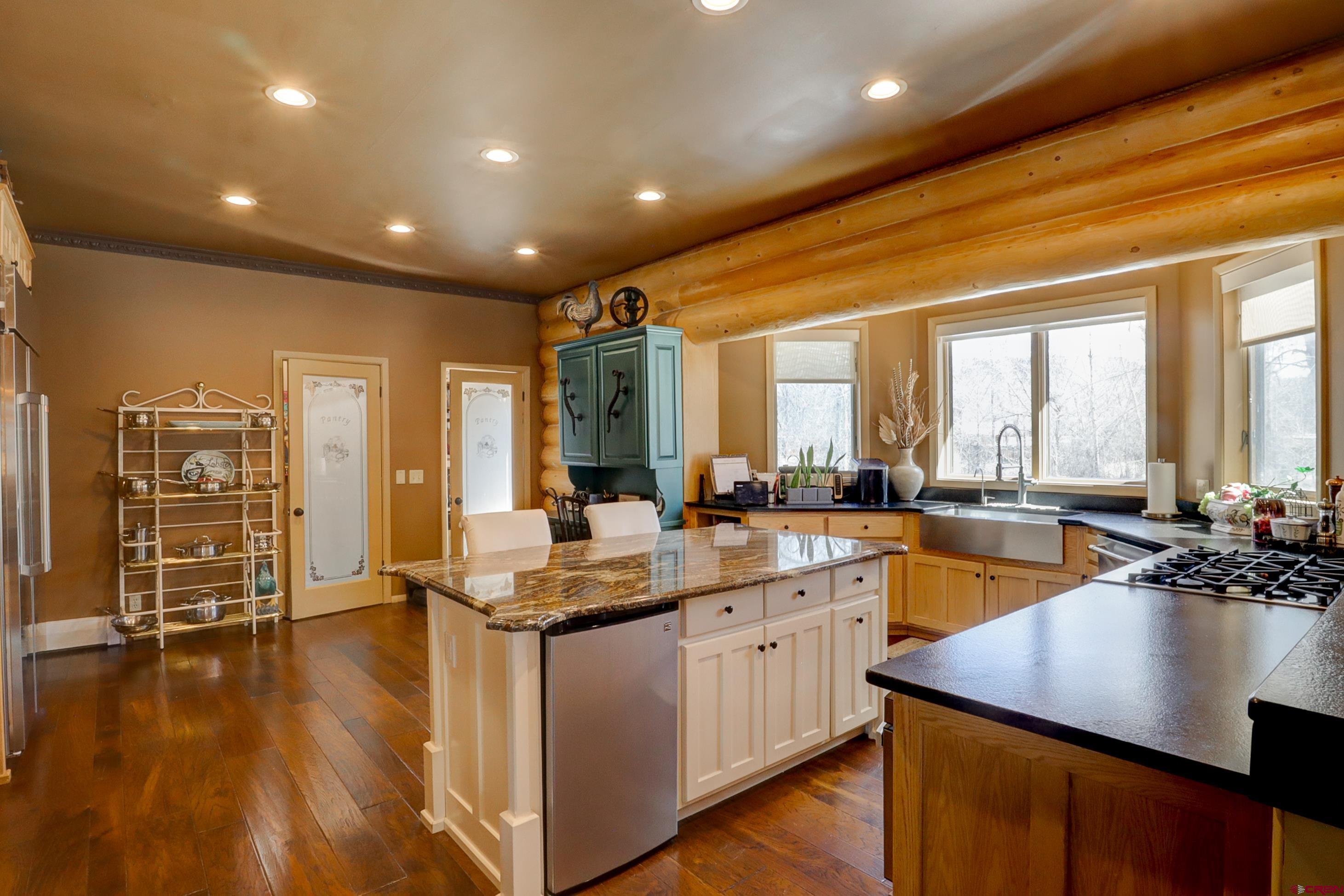18656 Highway 145 Dolores, CO 81323 - Photo 2 of 45 Kitchen featuring a sink, a center island, dark wood-style flooring, and stainless steel refrigerator