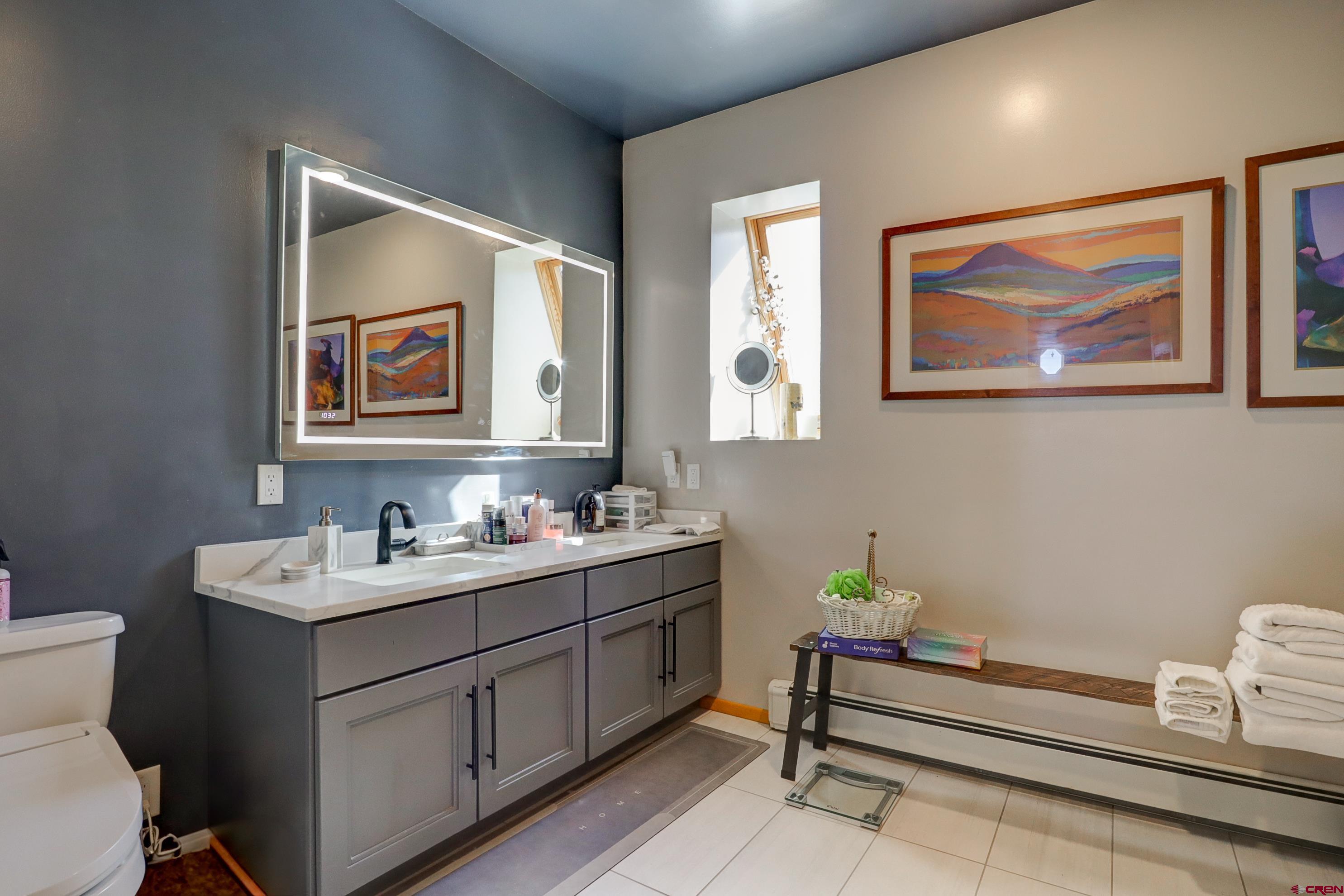 18656 Highway 145 Dolores, CO 81323 - Photo 25 of 45 Full bathroom featuring toilet, a sink, double vanity, a baseboard radiator, and baseboards