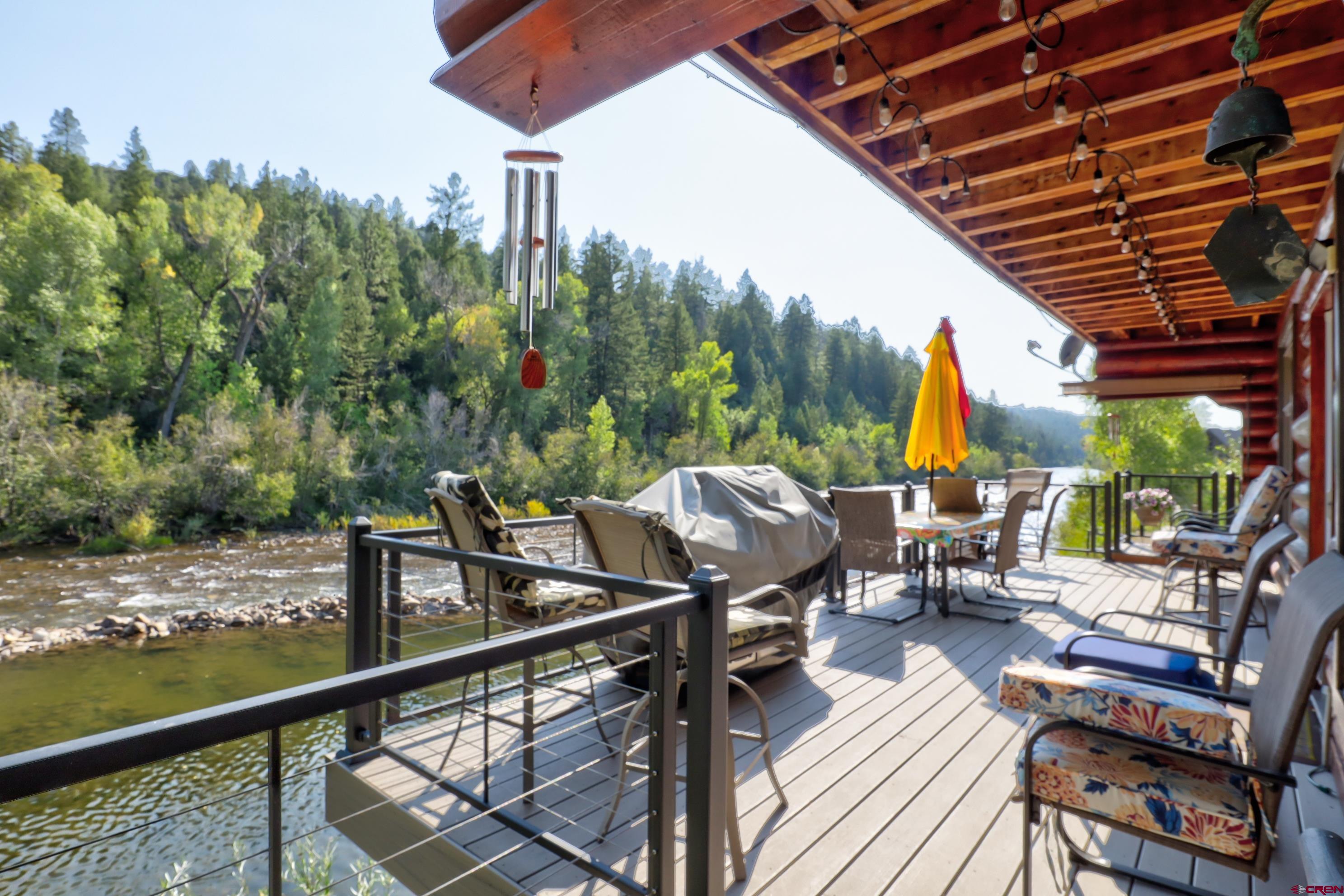 18656 Highway 145 Dolores, CO 81323 - Photo 32 of 45 Wooden deck with outdoor dining space, area for grilling, a view of trees, and a water view