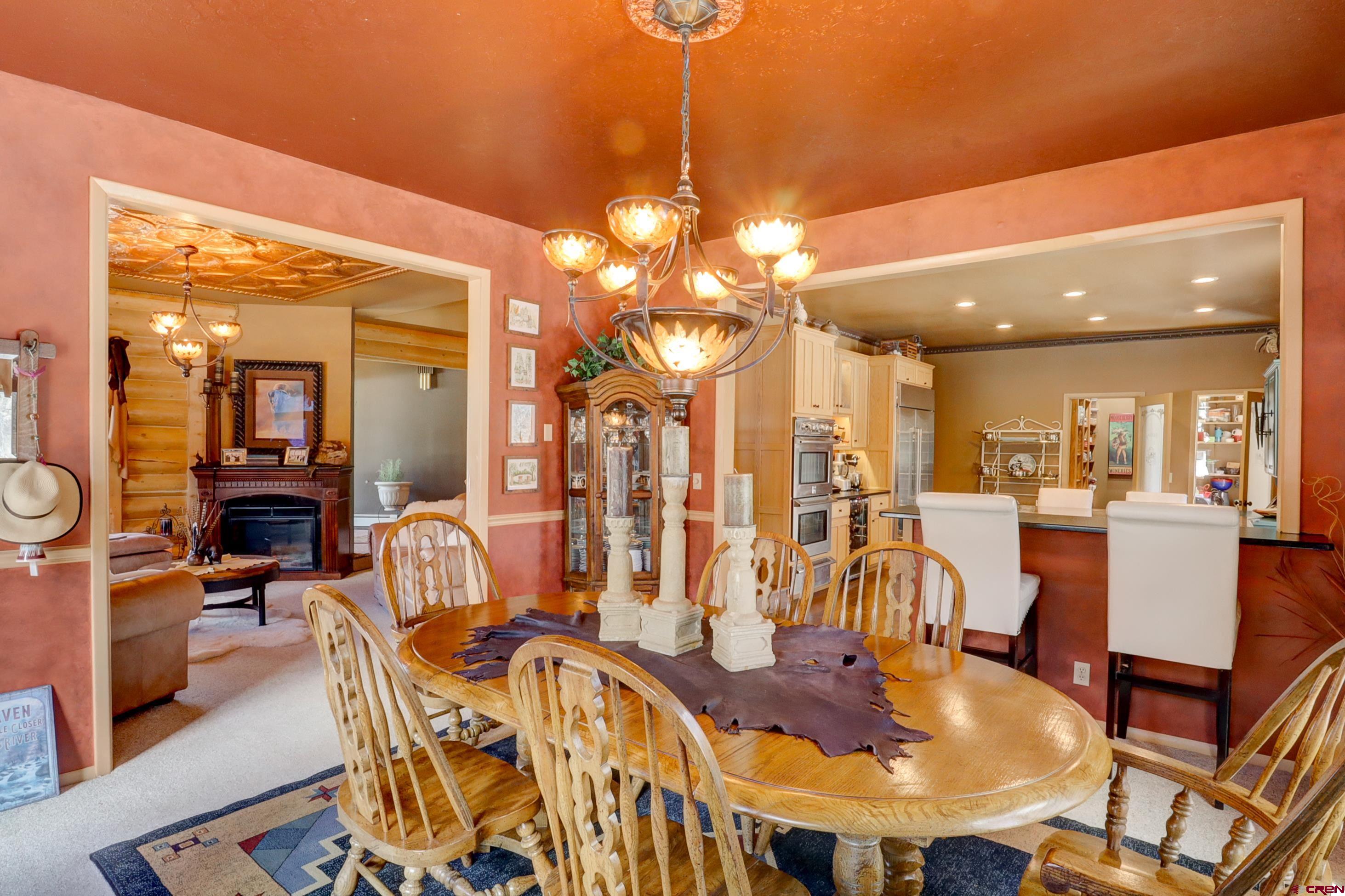 18656 Highway 145 Dolores, CO 81323 - Photo 7 of 45 Carpeted dining area with a glass covered fireplace, an inviting chandelier, and recessed lighting