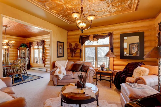 a living room with furniture a chandelier and a large window