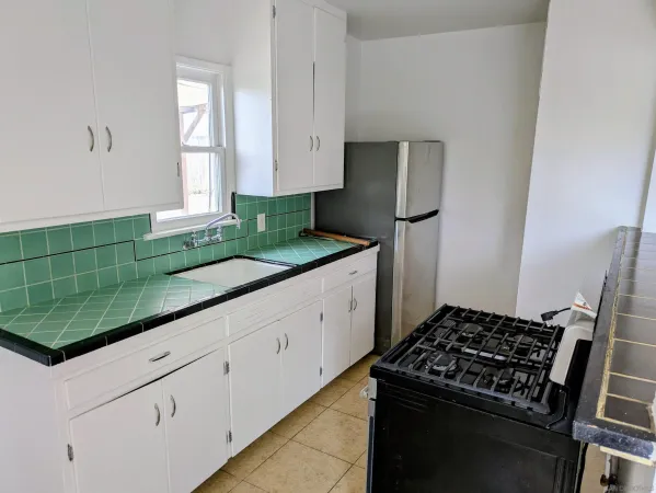 a kitchen with white cabinets and appliances