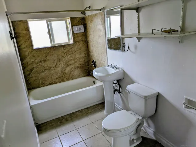 a bathroom with a sink a toilet a mirror and bathtub