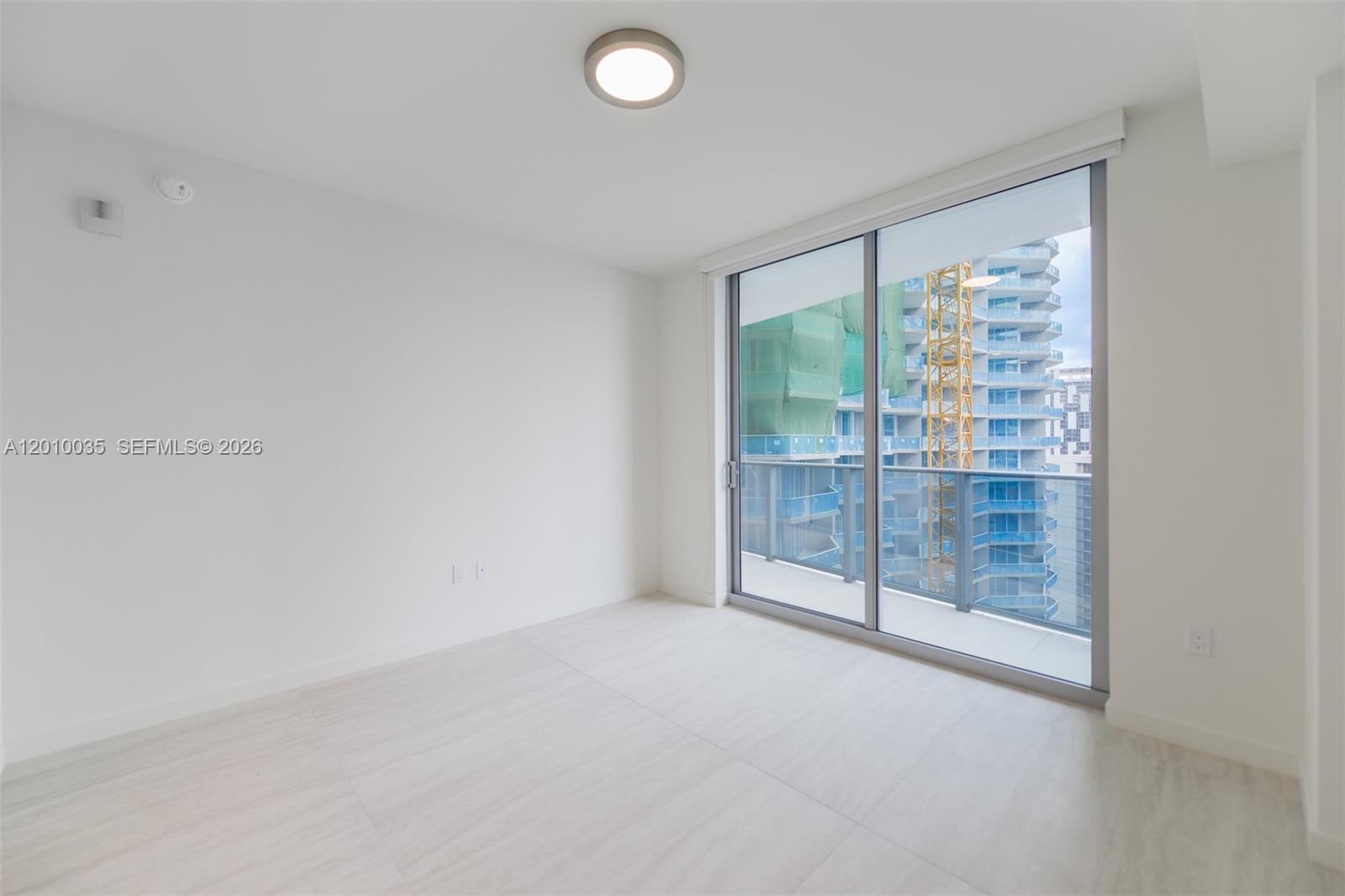 77 Southeast 5th Street, Unit 2603 Miami, FL 33131 - Photo 16 of 67 an empty room with sliding glass door and shower
