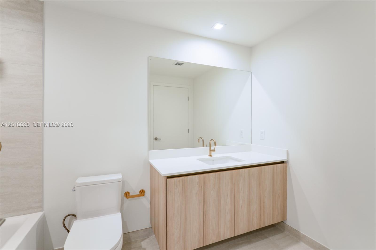 77 Southeast 5th Street, Unit 2603 Miami, FL 33131 - Photo 23 of 67 a bathroom with a granite countertop sink and a toilet