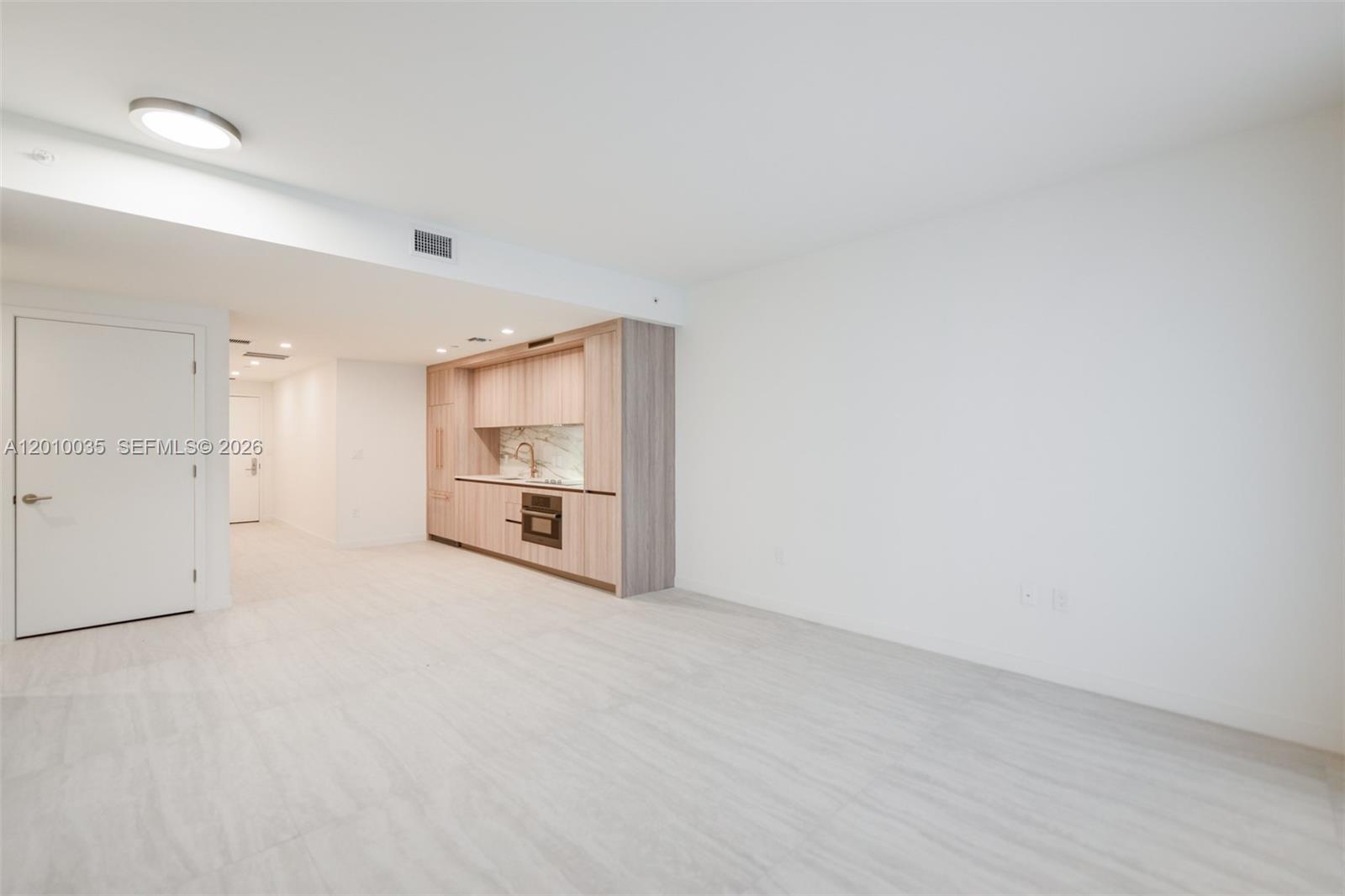 77 Southeast 5th Street, Unit 2603 Miami, FL 33131 - Photo 5 of 67 a view of an empty room with a kitchen