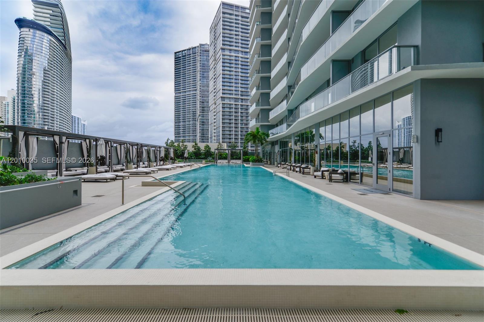 77 Southeast 5th Street, Unit 2603 Miami, FL 33131 - Photo 51 of 67 a swimming pool with outdoor seating and yard