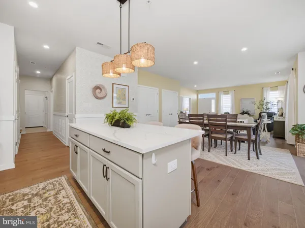 a large kitchen with kitchen island a counter space a sink appliances and a living room view