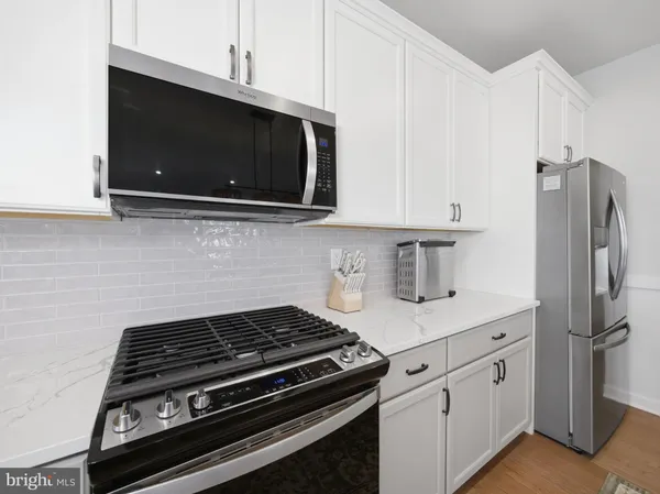 a kitchen with stainless steel appliances a stove a microwave a sink and cabinets