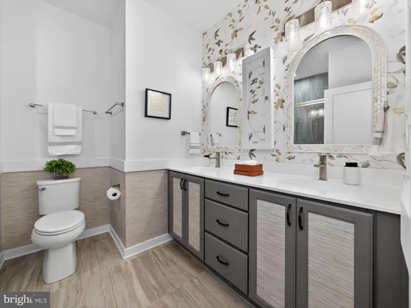 a spacious bathroom with a double vanity sink mirror and toilet