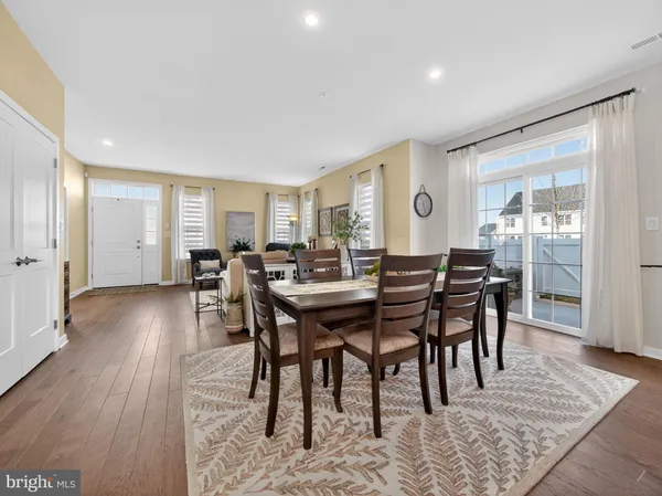 a view of a a dining room with furniture window and wooden floor