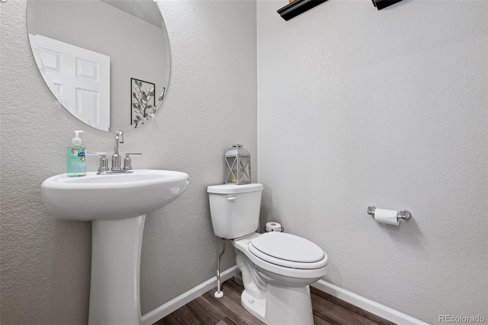 5097 Buckwheat Road Brighton, CO 80640 - Photo 11 of 28 a bathroom with a toilet sink and mirror