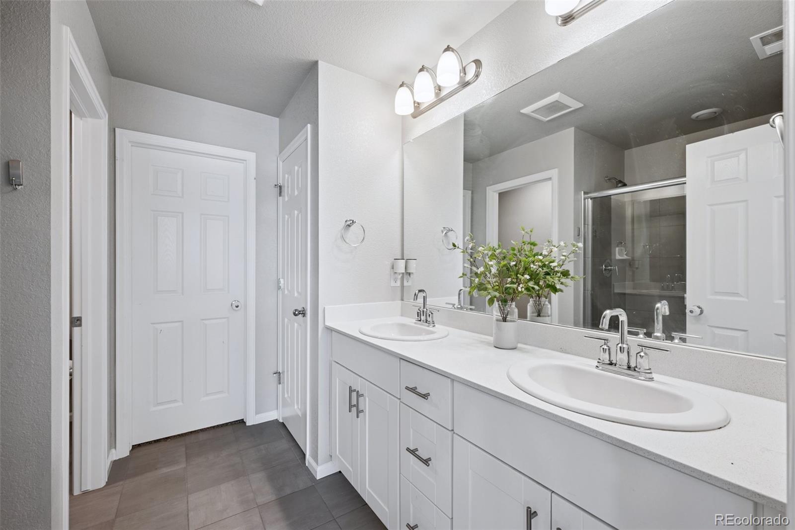 5097 Buckwheat Road Brighton, CO 80640 - Photo 16 of 28 a bathroom with a double vanity sink and a mirror