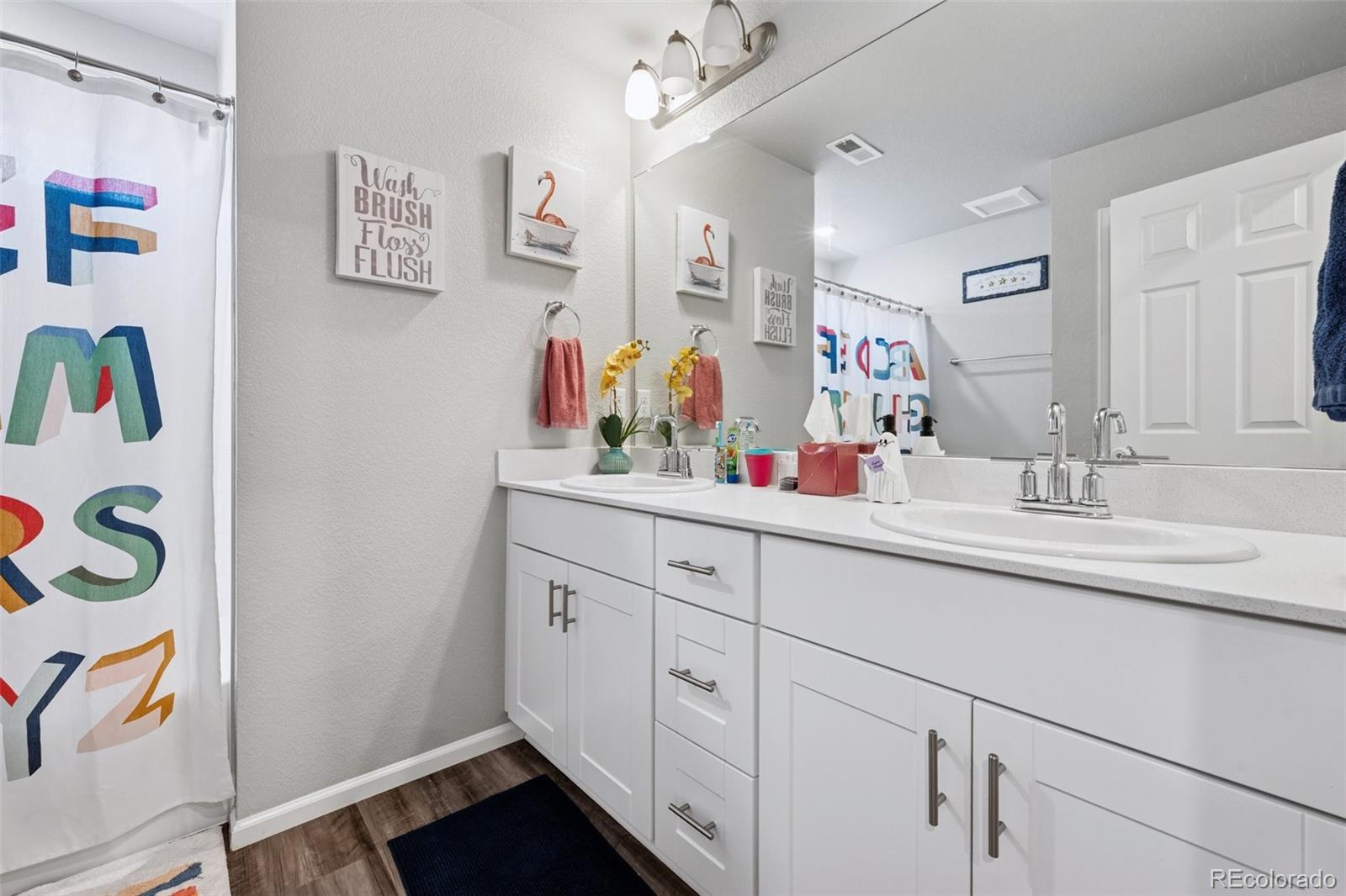 5097 Buckwheat Road Brighton, CO 80640 - Photo 18 of 28 a bathroom with a double vanity sink and a mirror