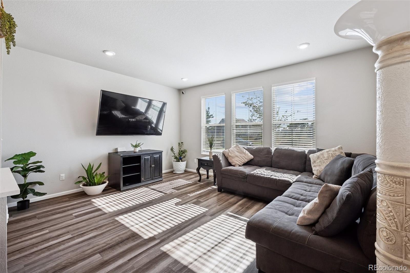 5097 Buckwheat Road Brighton, CO 80640 - Photo 4 of 28 a living room with furniture a flat screen tv and a fireplace