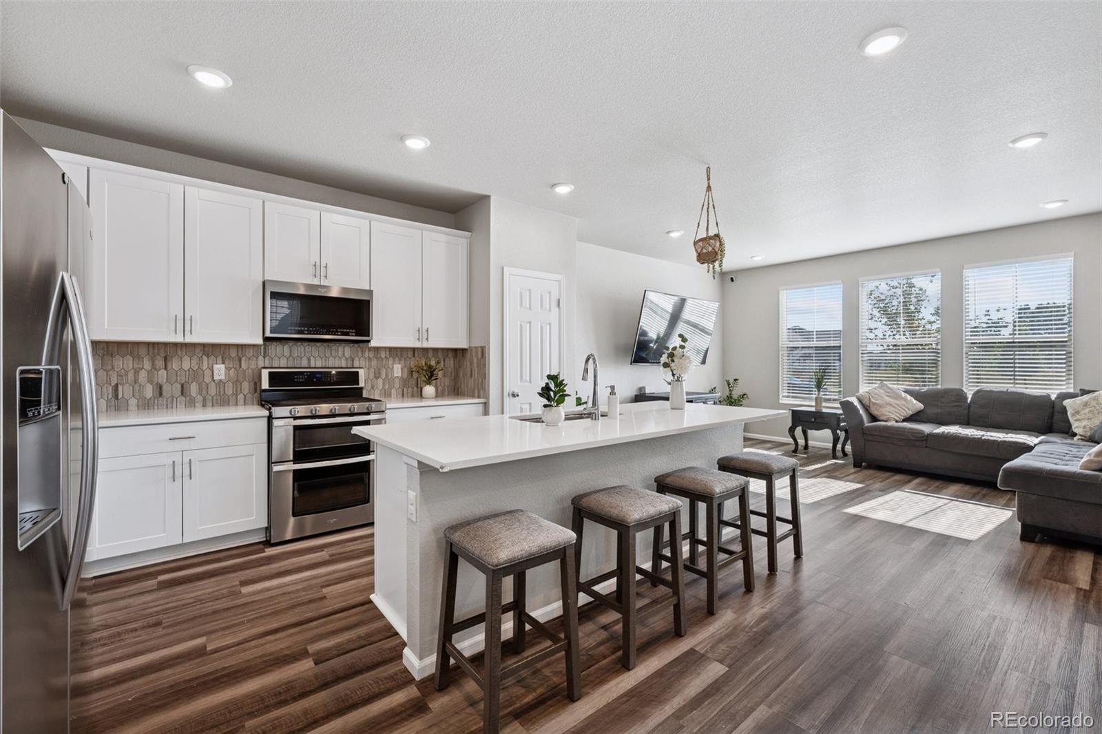 5097 Buckwheat Road Brighton, CO 80640 - Photo 9 of 28 a kitchen with kitchen island granite countertop a sink and counter space