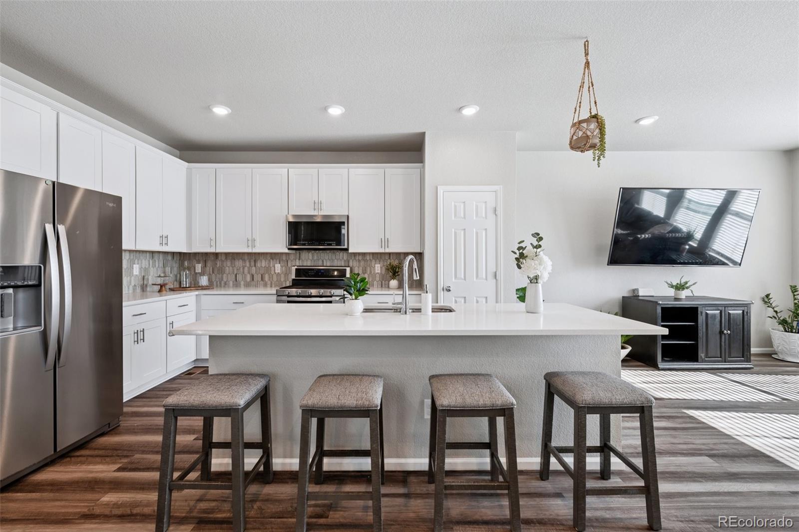 5097 Buckwheat Road Brighton, CO 80640 - Photo 10 of 28 a kitchen with refrigerator and chairs