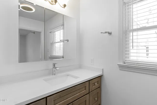 a bathroom with a granite countertop sink and a mirror