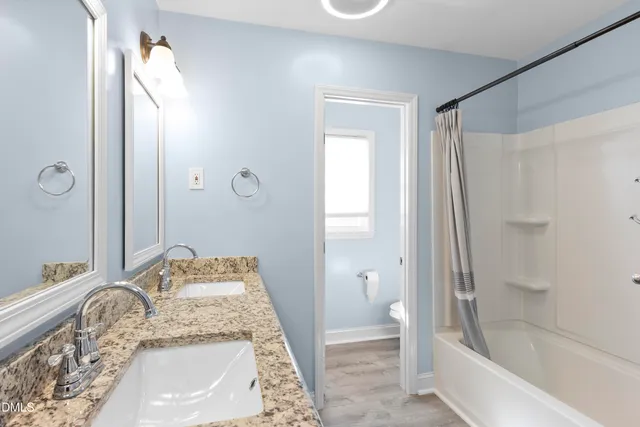 a view of a room with wooden floor and a ceiling fan