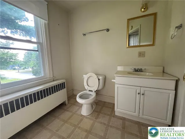 a bathroom with a sink toilet and a window