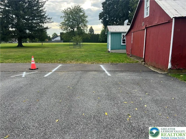 a view of a house with backyard and trees