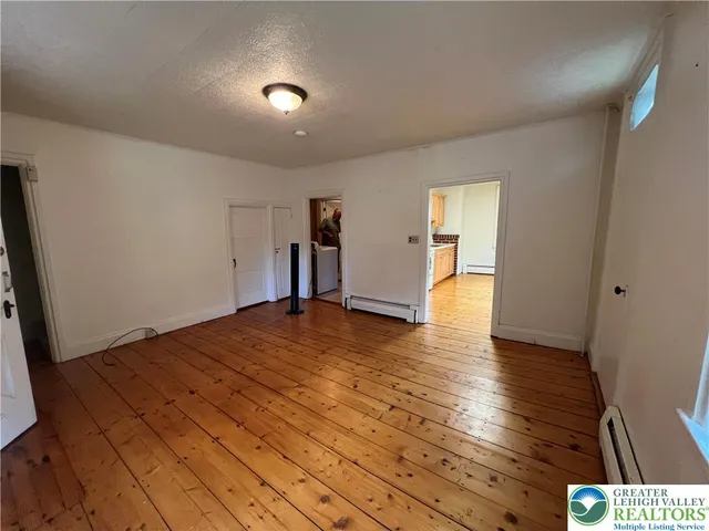 a view of empty room with wooden floor