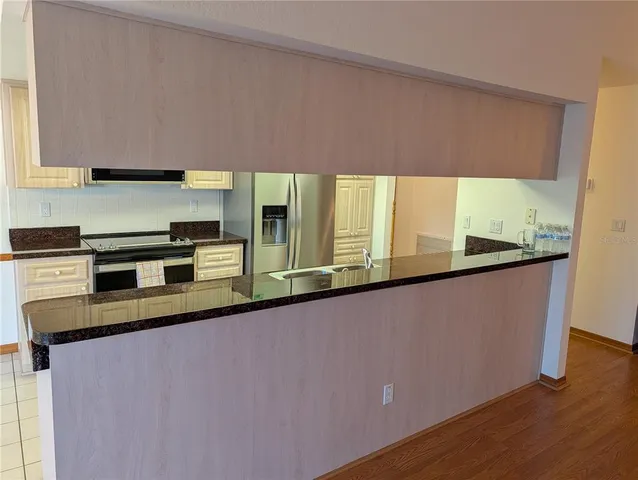 a kitchen with stainless steel appliances a counter space a sink a stove a microwave and cabinets