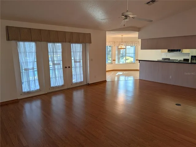 a view of a kitchen with wooden floor and a window