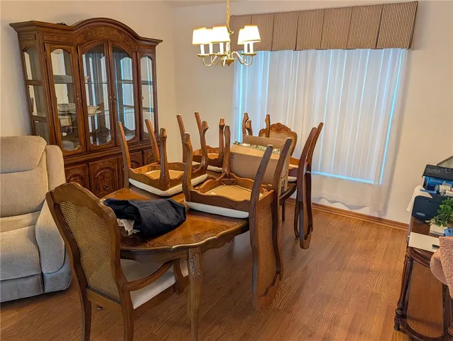 a dining room with furniture a chandelier and wooden floor