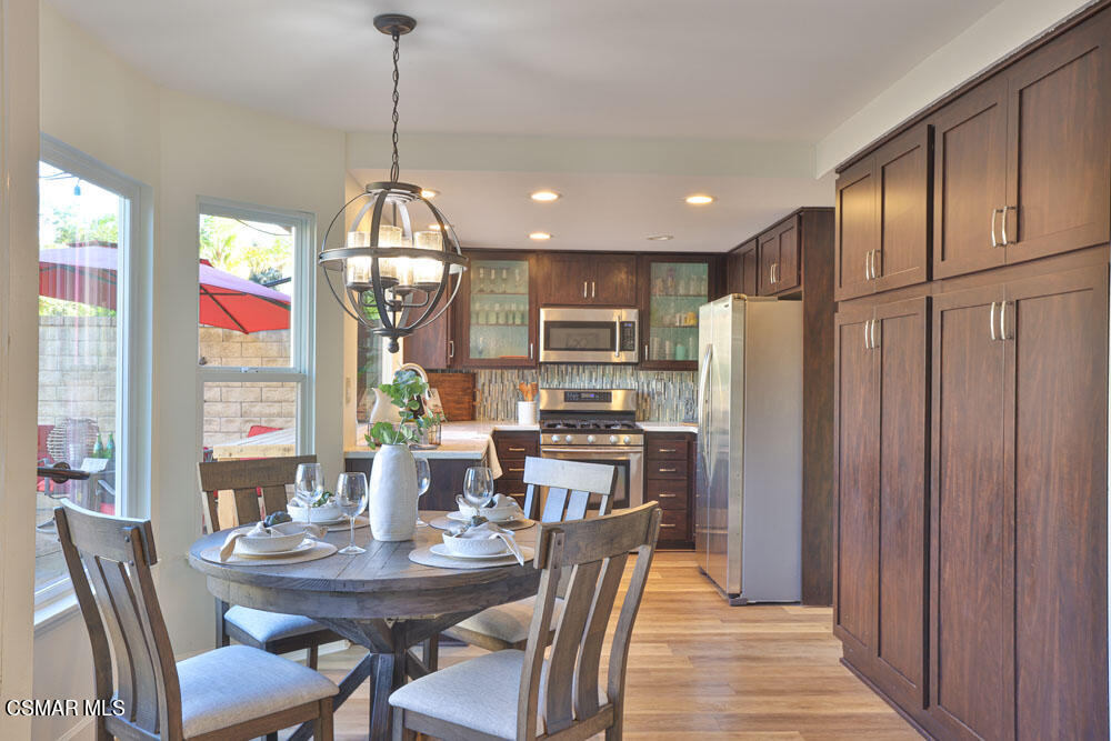 13520 Bear Valley Road Moorpark, CA 93021 - Photo 21 of 53 a dining room with stainless steel appliances granite countertop furniture a chandelier and wooden floor