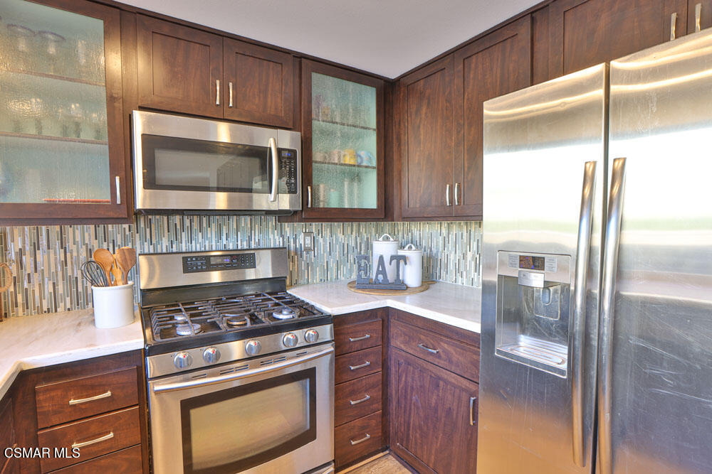 13520 Bear Valley Road Moorpark, CA 93021 - Photo 27 of 53 a kitchen with stainless steel appliances granite countertop a stove a refrigerator and a microwave