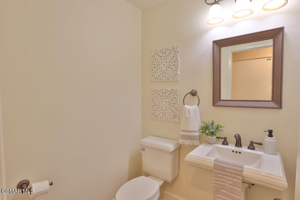 13520 Bear Valley Road Moorpark, CA 93021 - Photo 29 of 53 a bathroom with a toilet sink vanity and mirror