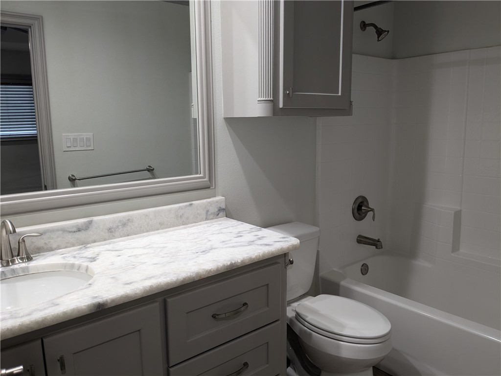 5375 County Road 73A, Unit D75 Robstown, TX 78380 - Photo 13 of 14 a bathroom with a granite countertop toilet sink and mirror