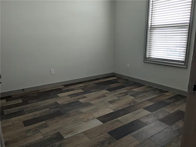 a view of a room with wooden floor and a window