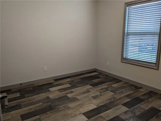 a room with a wooden floor and a window