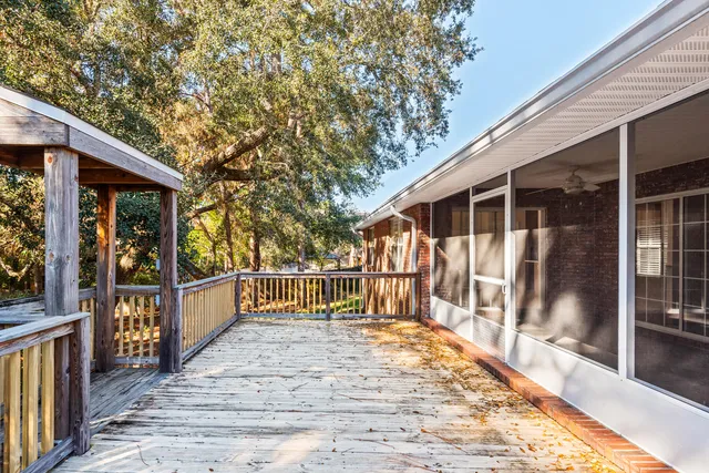 a view of a wooden deck and a yard with wooden fence