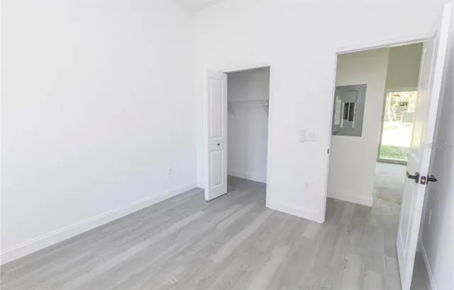 an empty room with wooden floor and a window