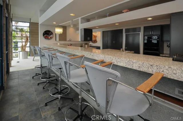 a view of a kitchen with kitchen island stainless steel appliances furniture stove top oven and sink