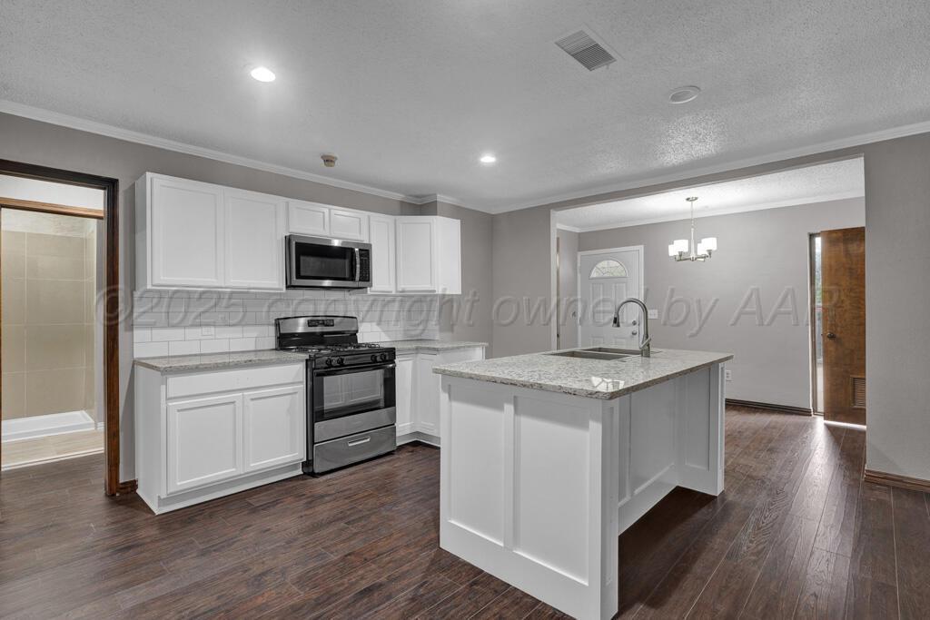 1022 Southwest 15th Avenue Amarillo, TX 79102 - Photo 6 of 11 a kitchen with a stove sink and a refrigerator