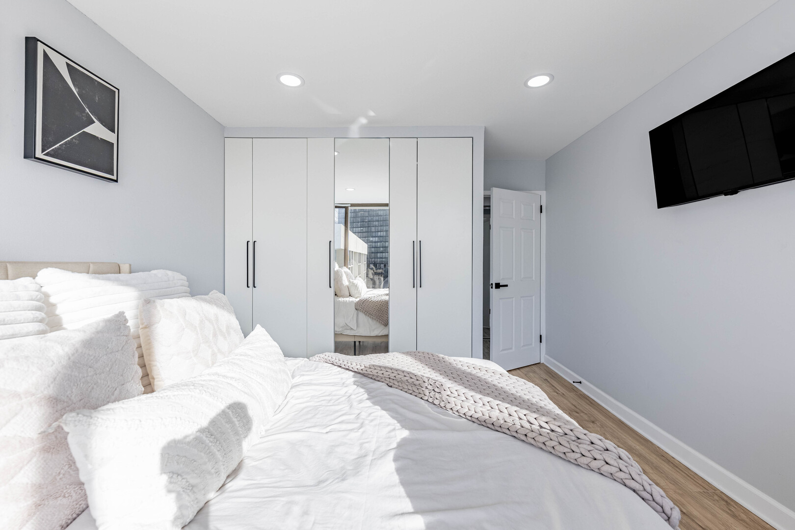 5455 North Sheridan Road, Unit 3906 Chicago, IL 60640 - Photo 12 of 28 a bedroom with a bed and a flat screen tv