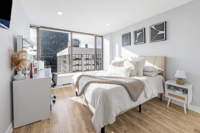 a bedroom with a bed and a large window