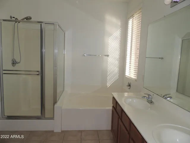 a bathroom with a tub sink shower and mirror